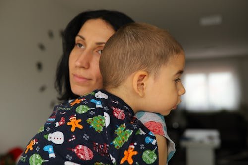 caring-mother-carrying-embracing A Mom Wants To Know If It's Normal She Can't Wait For Her Kid To Go To Bed