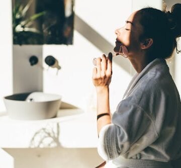 woman-doing-face-massage Why Is My Face So Puffy In The Morning? A Health Expert Explains