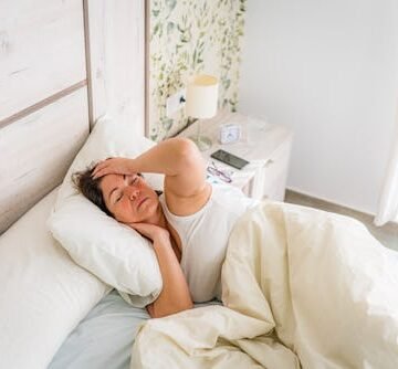 woman-in-bed-touching Waking Up With Headaches Every Morning? Here Are Some Possible Causes
