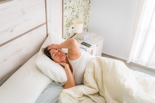 woman-in-bed-touching Waking Up With Headaches Every Morning? Here Are Some Possible Causes