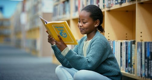 girl-reading-library-with Texas Bill Increases Scrutiny On School Libraries & Kids' Reading