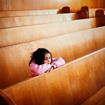 girl-sitting-at-pews Federal Administration Cuts Legal Aid To Unaccompanied Minors