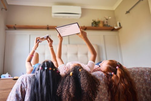 three-girls-lie-on Reddit Asks: Are Screen-Heavy Sleepovers The New Reality?